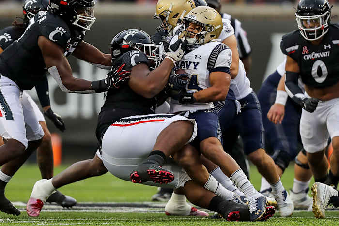 Nov 5, 2022; Cincinnati, Ohio, USA; Cincinnati Bearcats defensive lineman Dontay Corleone (58) brings down Navy Midshipmen fullback Anton Hall Jr. (34) in the first half at Nippert Stadium. Mandatory Credit: Katie Stratman-USA TODAY Sports